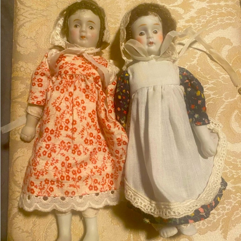 2 antique porcelain dolls / bonnets and pilgrim like dresses. Approx 12”